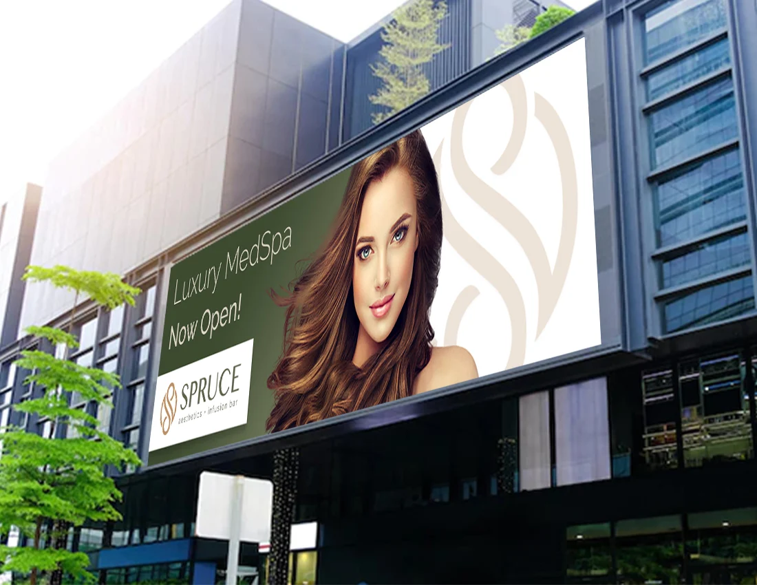 A large billboard advertises Luxury MedSpa Now Open! with a womans face, the Spruce MedSpa logo, and building reflections in the background.